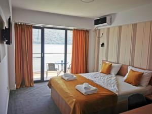 a hotel room with a bed with towels on it at Pensiunea Sunshine in Eşelniţa +74 photos