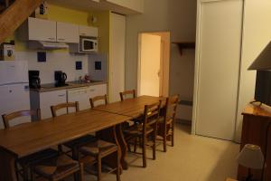 uma cozinha com uma longa mesa de madeira e cadeiras em Résidence Mille Soleils - Font Romeu em Font Romeu Odeillo Via