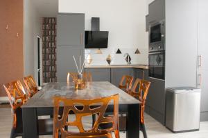 eine Küche mit einem Esstisch und Stühlen in der Unterkunft 15ème droite - Tour Perret - Centre-Ville - 4 étoiles in Amiens