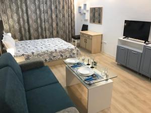 a small living room with a couch and a tv at Студио Сънрайз А28, Лозенец in Lozenets