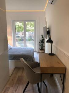 Un dormitorio con una cama, un escritorio y una silla. en Apartments The Space, en Drawsko Pomorskie