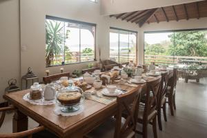 a long table with food on it in a room with windows at GUAPAS BUZIOS Exceptional House - Ferradurinha in Búzios
