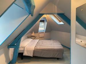 une chambre avec un lit dans un grenier dans l'établissement Bois Flotté, au Tréport