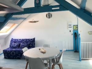 Cette chambre comprend une table et un canapé violet. dans l'établissement Bois Flotté, au Tréport