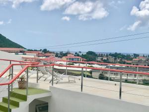 un balcone con tavoli e sedie in un edificio di Cleopatra Villas - Sea View a Rodney Bay Village