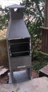 a barbecue grill sitting on the ground in a yard at GUAPAS BUZIOS Exceptional House - Ferradurinha in Búzios