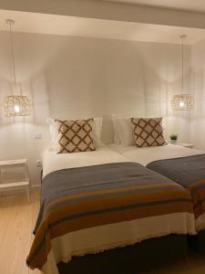 a bedroom with two beds and two lights at Sal da Terra in Nazaré