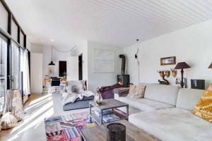 a living room with a white couch and a table at Cozy summer house 50 meter from the beach, 89 m² in Dronningmølle