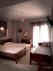 a bedroom with two beds and a window at Adonis Apartments in Paralia Katerinis