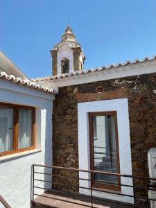 une façade de maison avec un clocher dans l'établissement Casa da Igrejja, à Almodôvar