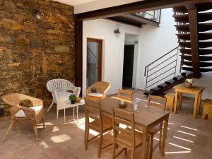 a patio with a wooden table and chairs and a stone wall at Casa da Igrejja in Almodôvar
