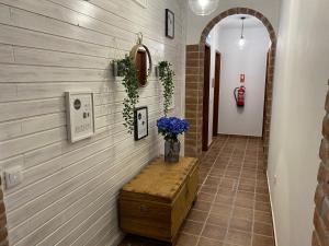 a hallway with a table and flowers on a wall at Casa da Igrejja in Almodôvar