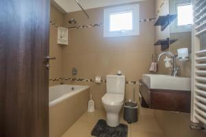 a bathroom with a toilet and a tub and a sink at Ariella Villa in Protaras +15 photos