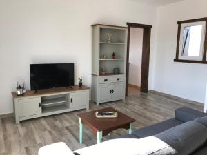 uma sala de estar com um sofá e uma televisão em Eslanzarote Eco Country House, Star View Area, Super wifi, Barbecue em Teguise