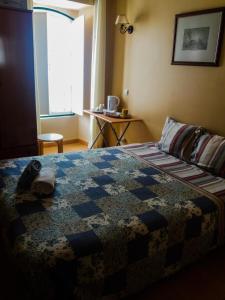 a bedroom with a bed with a quilt on it at Guest House Capitao Mor in Faro