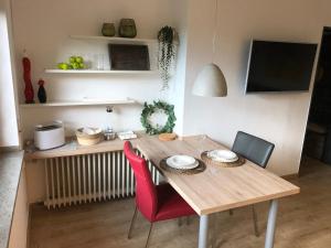 une table à manger avec deux chaises rouges et une table dans l'établissement Burgblick, à Nideggen