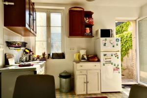 - une cuisine équipée d'un réfrigérateur blanc avec des aimants dans l'établissement Maison de Pêcheur à Villerville, à Deauville