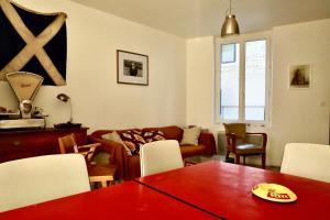 sala de estar con mesa roja y sofá en Maison de Pêcheur à Villerville, en Deauville