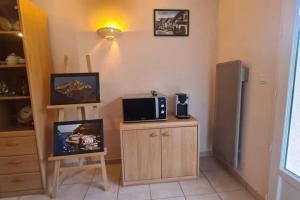 a kitchen with a microwave on a counter with a refrigerator at Petite maison aux abords de Bagnères de Bigorre in Bagnères-de-Bigorre