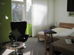 Dormitorio con silla, cama y escritorio en Hotel-Café "Schauinsland", en Horn-Bad Meinberg