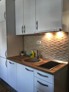 a kitchen with white cabinets and a sink at Apartman Tijana in Budva