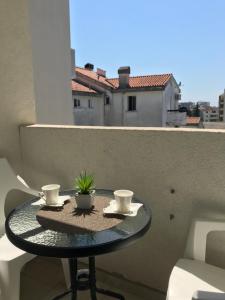 a table on a balcony with two cups on it at Apartman Tijana in Budva