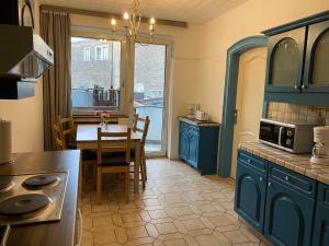 eine Küche mit blauen Schränken und einem Tisch mit einem Esszimmer in der Unterkunft Central Shared Apartment, Friesenplatz in Köln