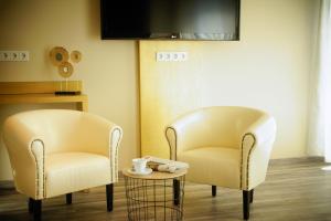 two chairs and a table in a room at Hotel Athen Kelsterbach Frankfurt Airport in Kelsterbach