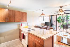 a kitchen with wooden cabinets and a white stove top oven at Maui Vista in Kihei