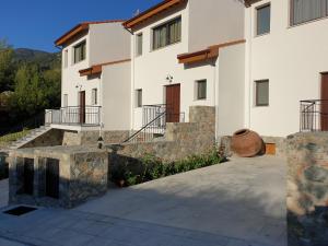 a large white building with stairs and a building at Melissonas Villas in Phini