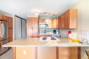 eine Küche mit Holzschränken und einer Arbeitsplatte in der Unterkunft Amazing Kihei Kai Nani - Maui Vista One Bedroom Condos in Kihei