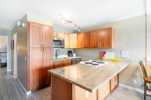 a kitchen with wooden cabinets and a counter top at Amazing Kihei Kai Nani - Maui Vista One Bedroom Condos in Kihei