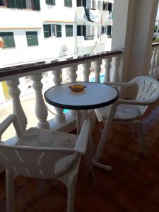 a table and chairs on a balcony at Apartamentos Xoroi in Cala en Porter