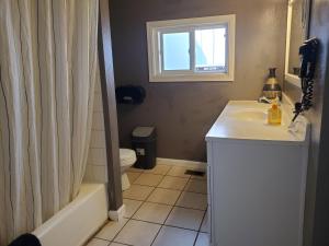 a bathroom with a sink and a toilet and a window at Yosemite International Hostel in Groveland