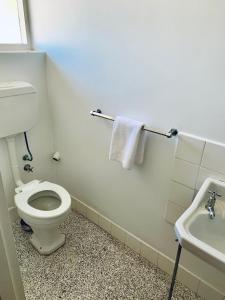 een witte badkamer met een toilet en een wastafel bij Coonalpyn Hotel in Coonalpyn