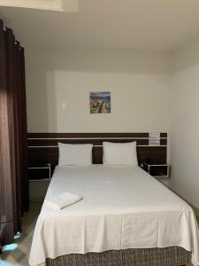 ポルト・ヴェーリョにあるSAMIR HOTEL COMFORTのベッド(白いシーツ、枕付)