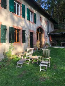 three chairs and a table in front of a house at B & B Maison Helise in La Croix-aux-Mines