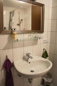 a bathroom with a sink and a mirror at Hotel am Schloss Neuenstein in Neuenstein