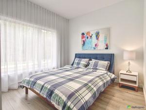 a bedroom with a blue bed and a window at Le sommet du golf avec SPA in Saint-Jean-de-Matha