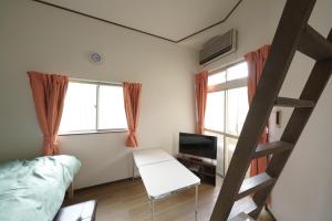 a bedroom with a bunk bed and a desk and a ladder at Garden house Ozasa - Apartment STAY in Fukuoka