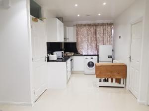 a white kitchen with a refrigerator and a dishwasher at Observation Court in Ipswich