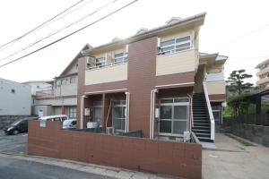 a building with a brick wall in front of it at Garden house Ozasa - Apartment STAY in Fukuoka