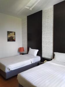 a hotel room with two beds and two lamps at Ginasuite Kompleks27 Hotel in Bandar Seri Begawan