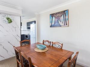 a dining room with a wooden table and chairs at Heritage 202 in Tuncurry +7 photos