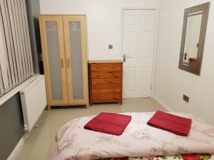 a bedroom with a bed with two red towels on it at Orwell Suite in Ipswich