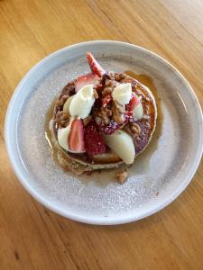 a plate of pancakes with fruit and nuts on a table at Peppers Silo in Launceston