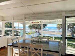 a dining room with a table and views of the ocean at Golden Sands at Beachmere in Beachmere