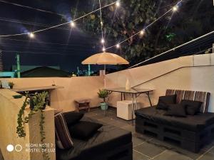 patio con tavolo, divano e ombrellone di Hostel de Luz - Unidade 1 a Campinas