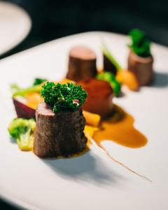 a plate of food with meat and vegetables on it at Fiordland Lodge in Te Anau