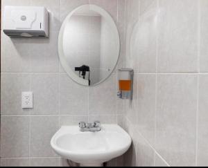 Baño blanco con lavabo y espejo en Hotel CALLI YOLOTL Teotihuacan, en San Juan Teotihuacán